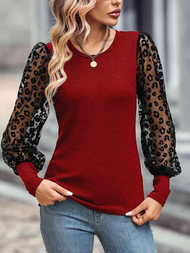 a woman wearing a red top with leopard print sleeves