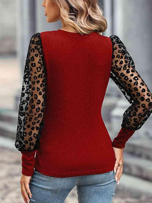 a woman wearing a red top with leopard print sleeves