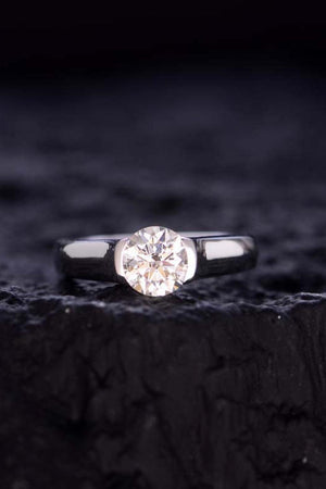 a close up of a diamond ring on a rock