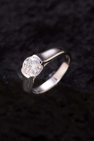 a diamond ring sitting on a black surface