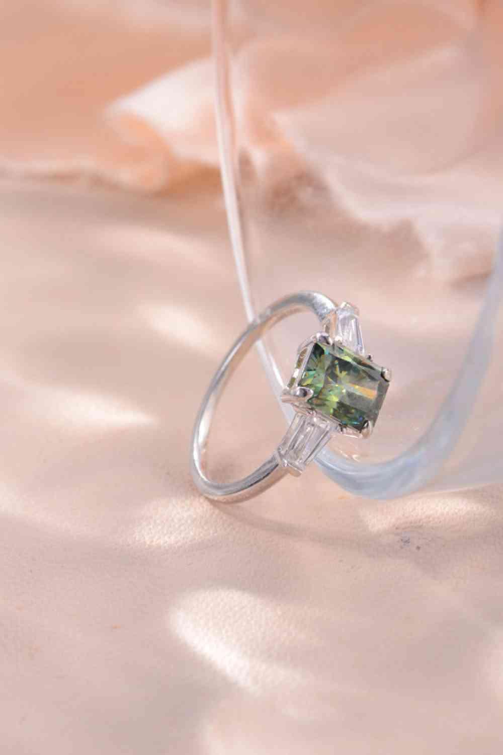 a close up of a ring with a green stone