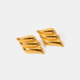 a pair of gold earrings on a white background