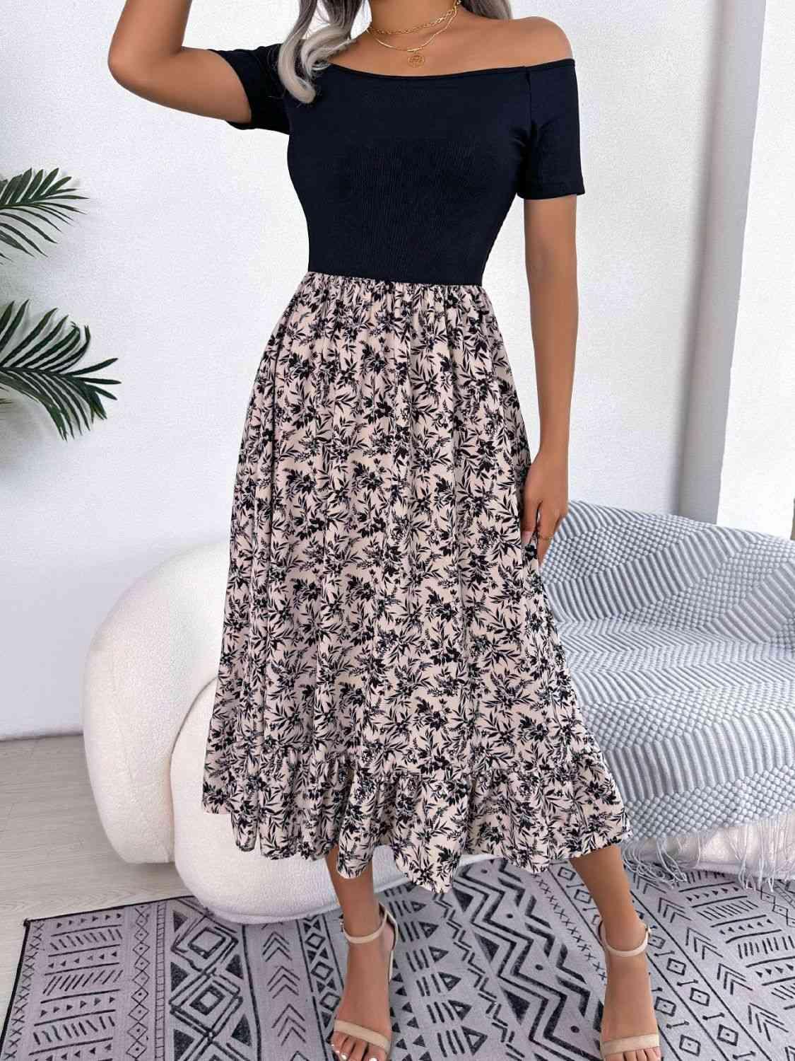 a woman wearing a black top and a floral print skirt