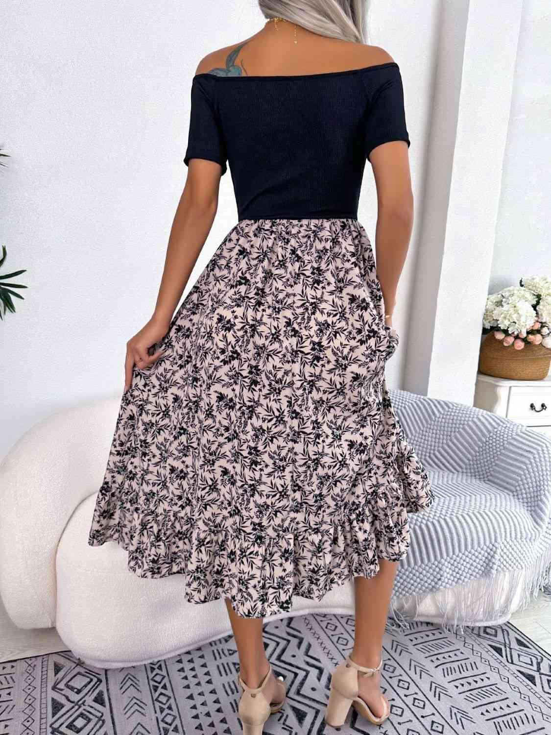 a woman wearing a black top and a floral print skirt