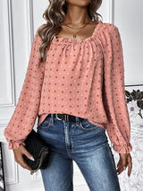a woman wearing a pink blouse and jeans