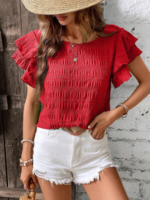 a woman wearing a straw hat and red top