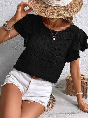 a woman wearing a straw hat and black top