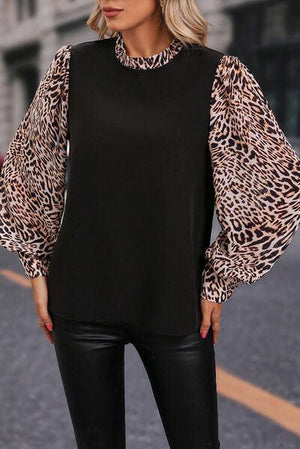 a woman wearing a black top with a leopard print sleeve