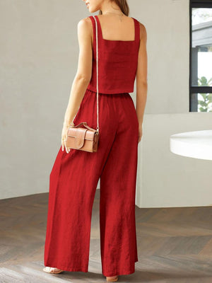 a woman wearing a red jumpsuit and a handbag