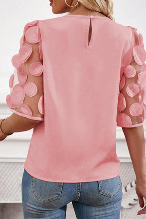 a woman wearing a pink top with polka dots
