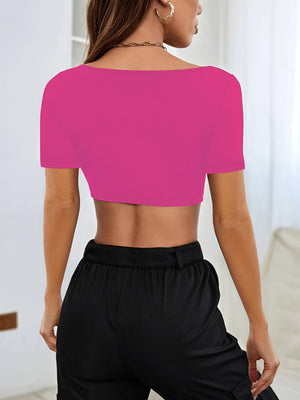 a woman wearing a pink crop top and black pants