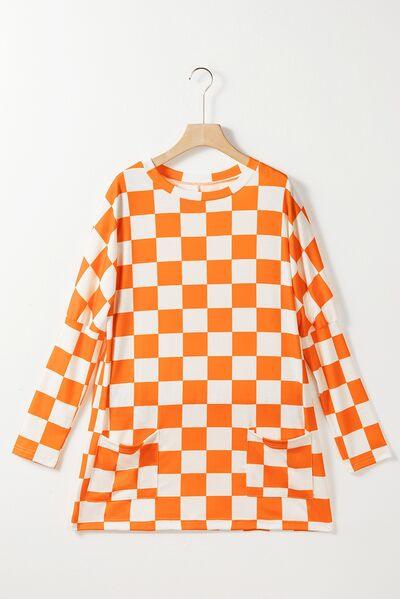 an orange and white checkered shirt hanging on a hanger