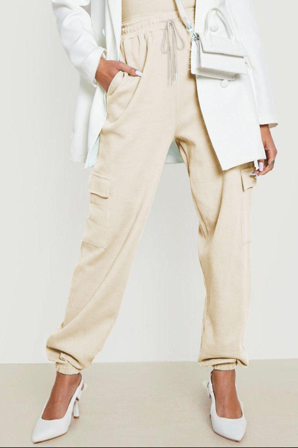 a woman wearing a white jacket and pants