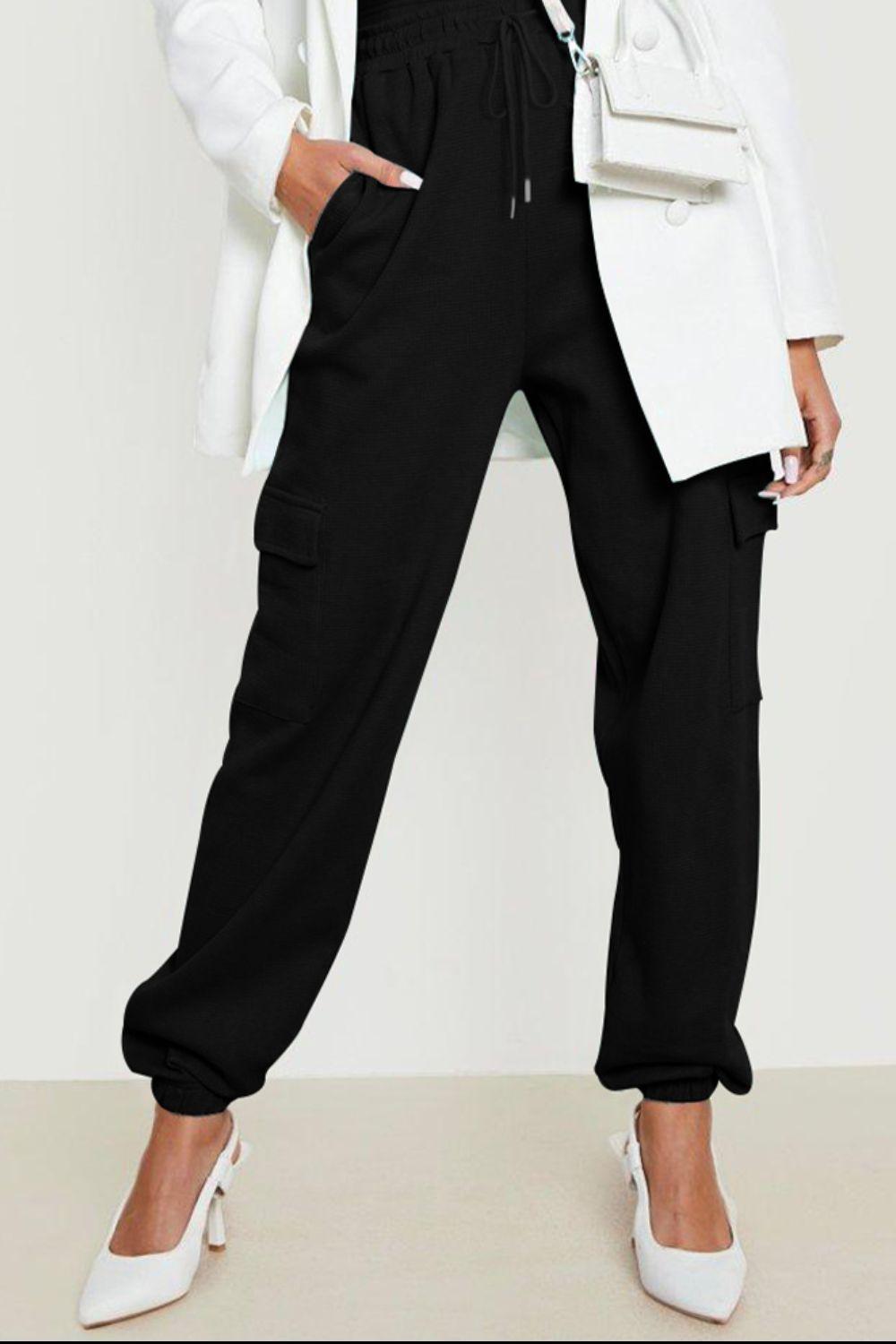 a woman in a white jacket and black pants