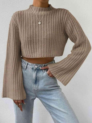 a woman wearing a cropped sweater and jeans