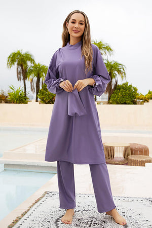 a woman in a purple outfit standing by a pool