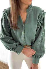 a woman wearing a green blouse and white pants