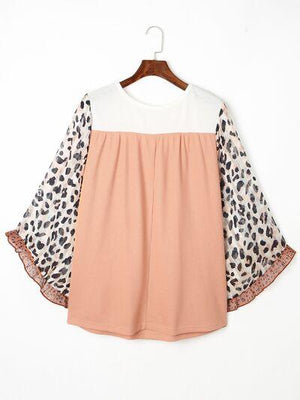 a top with a leopard print on the sleeves