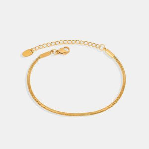 a gold bracelet with a clasp on a white background