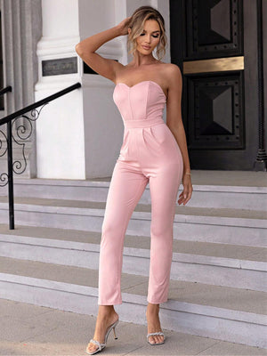 a woman in a pink jumpsuit posing for a picture