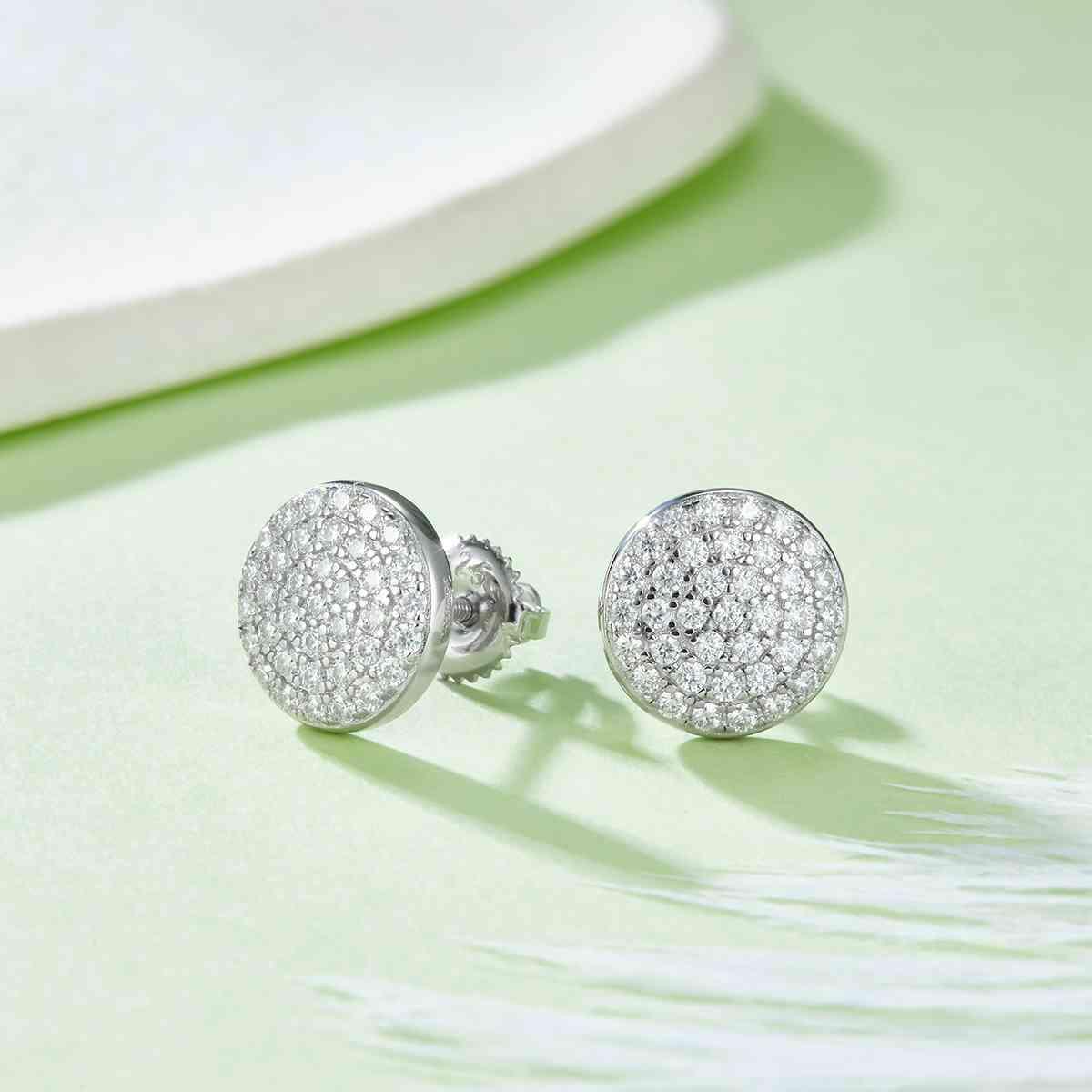 a pair of diamond earrings sitting on top of a table