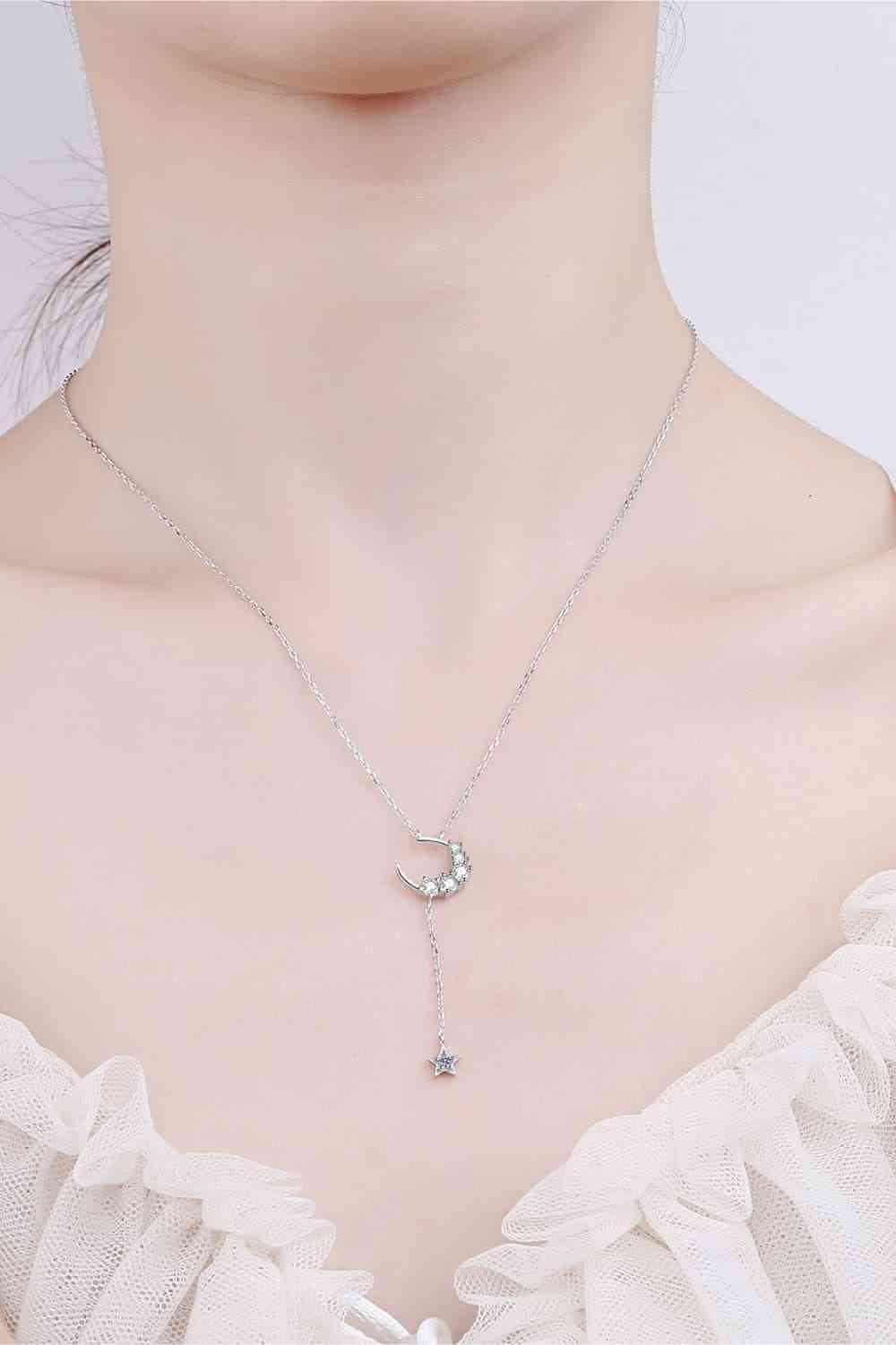 a woman wearing a necklace with a star and moon on it