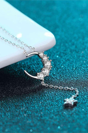 a necklace with a crescent and stars hanging from it