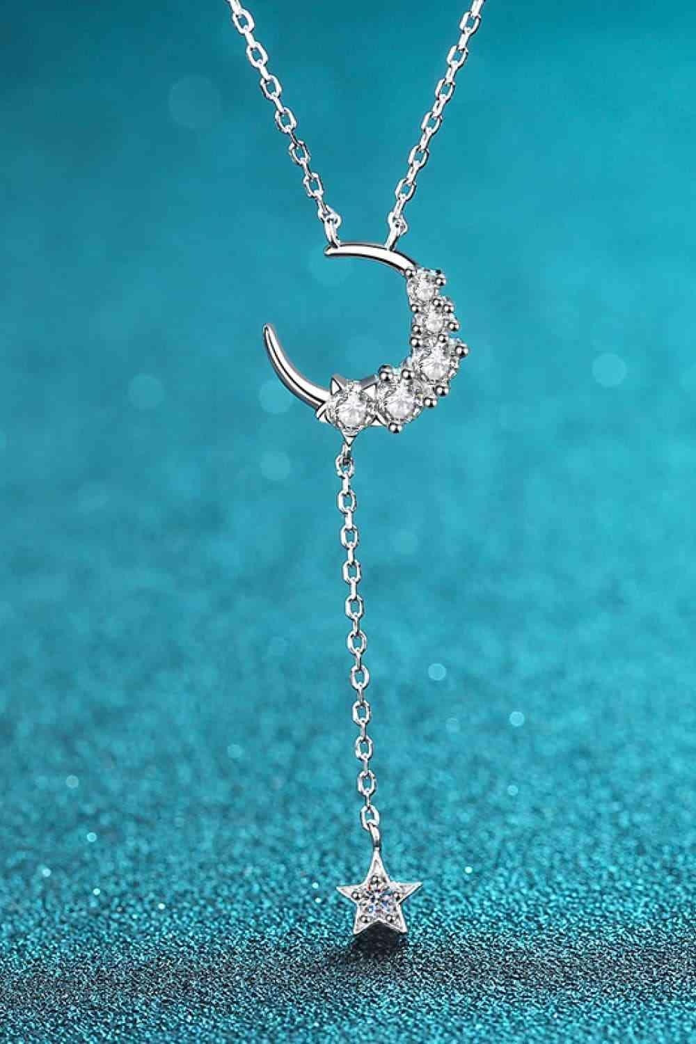 a necklace with a crescent and stars hanging from it