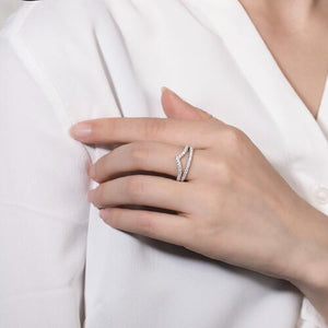 a woman wearing a white shirt and a diamond ring