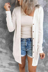 a woman wearing a white cardigan and denim shorts