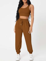 a woman wearing a brown crop top and pants