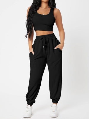 a woman wearing a black crop top and pants
