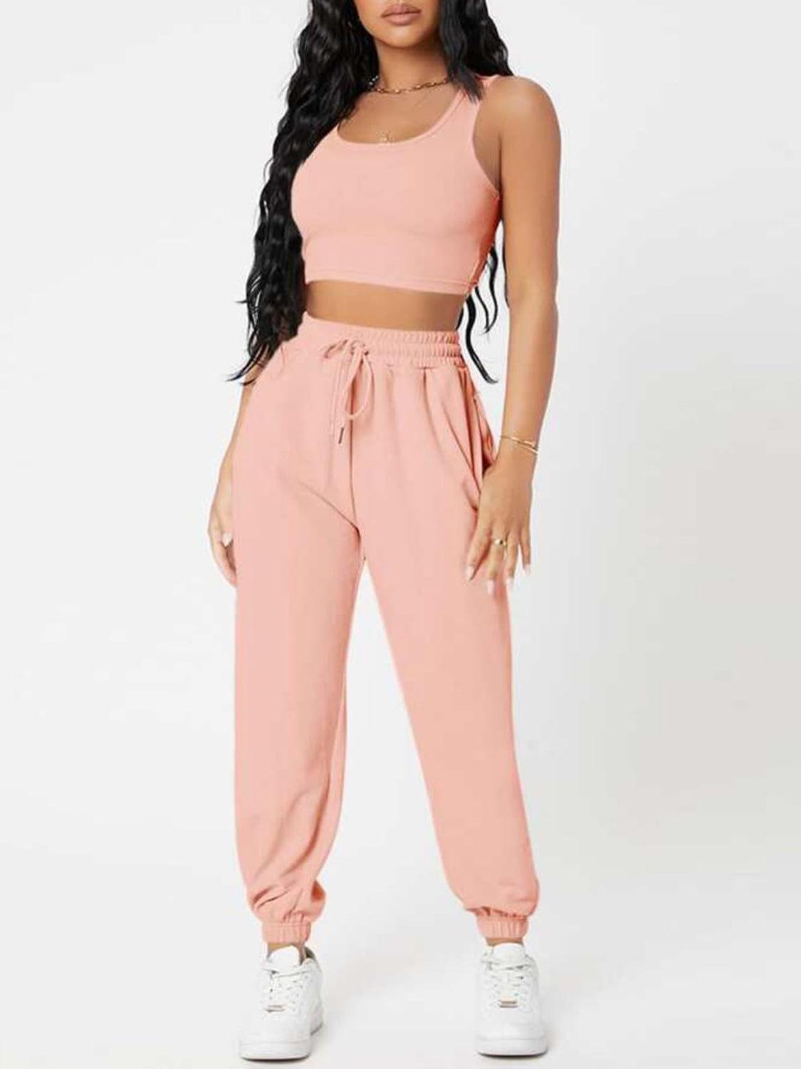 a woman wearing a pink crop top and sweat pants