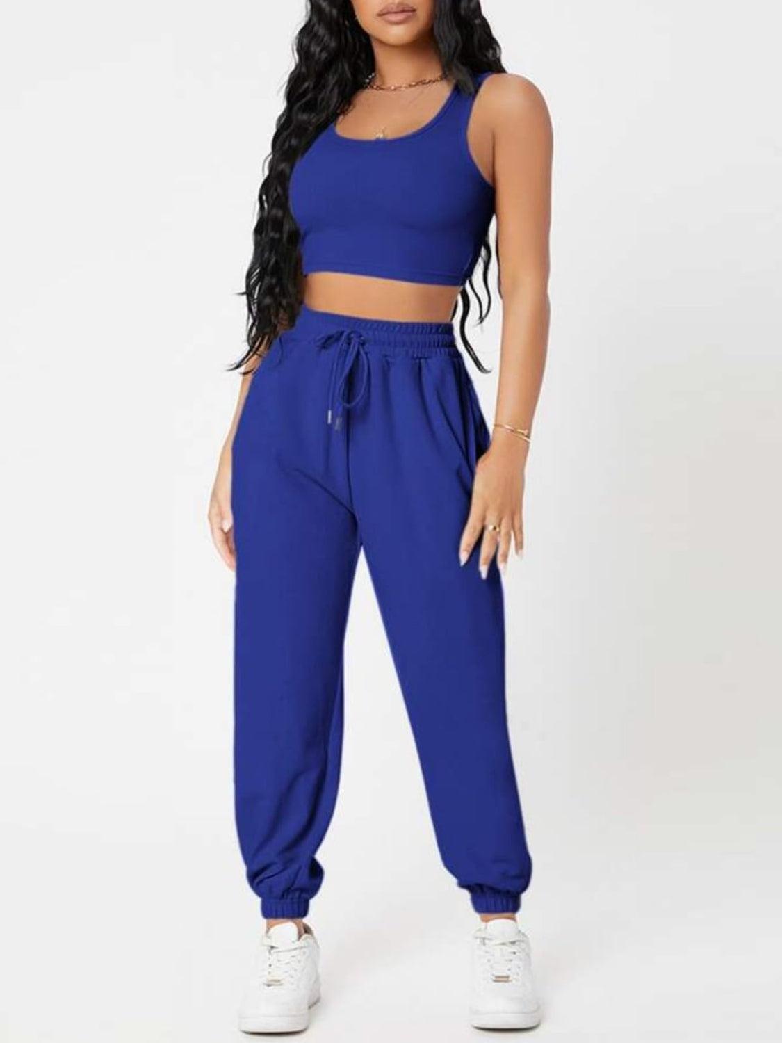 a woman wearing a blue crop top and sweat pants