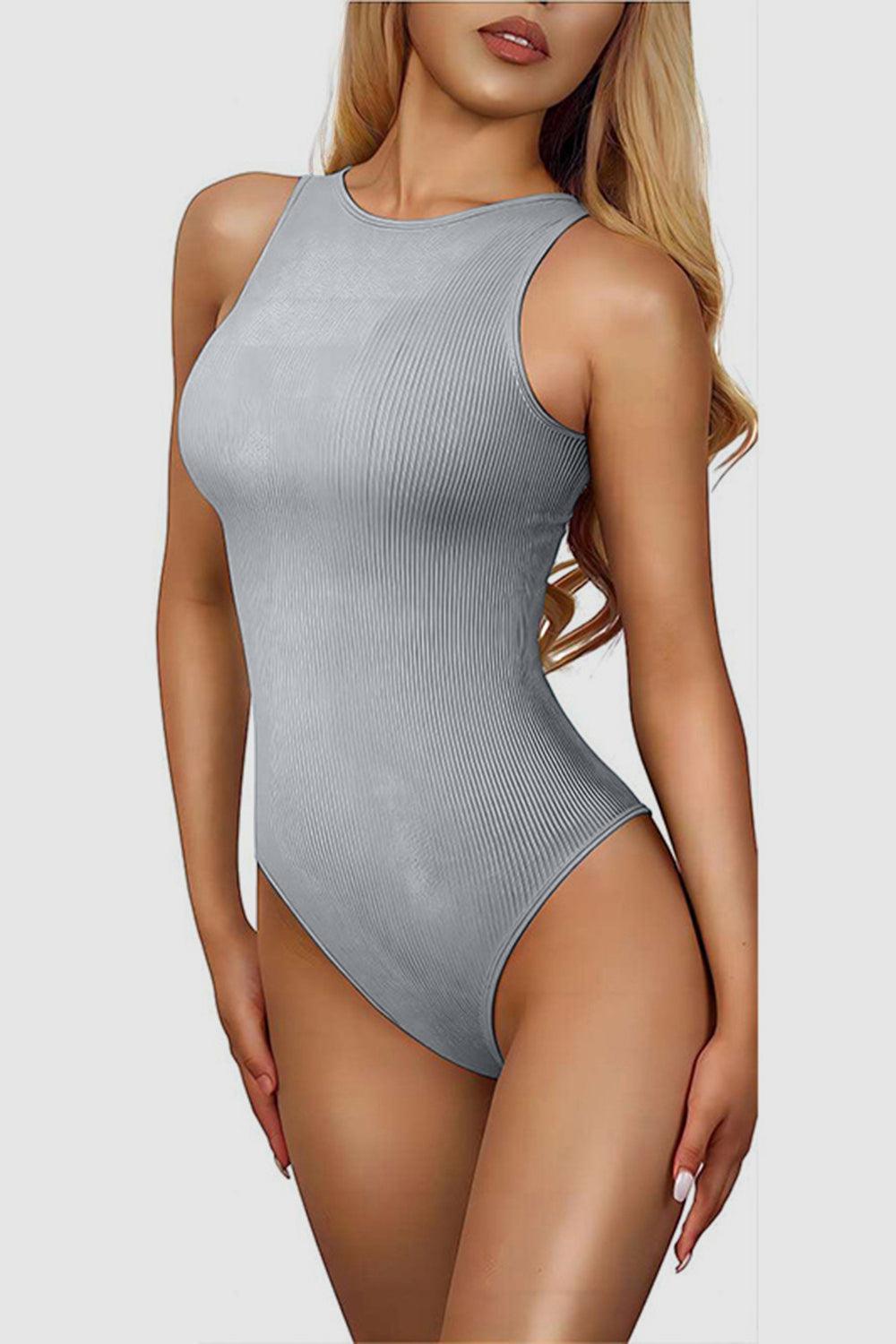 a woman in a gray bodysuit posing for a picture