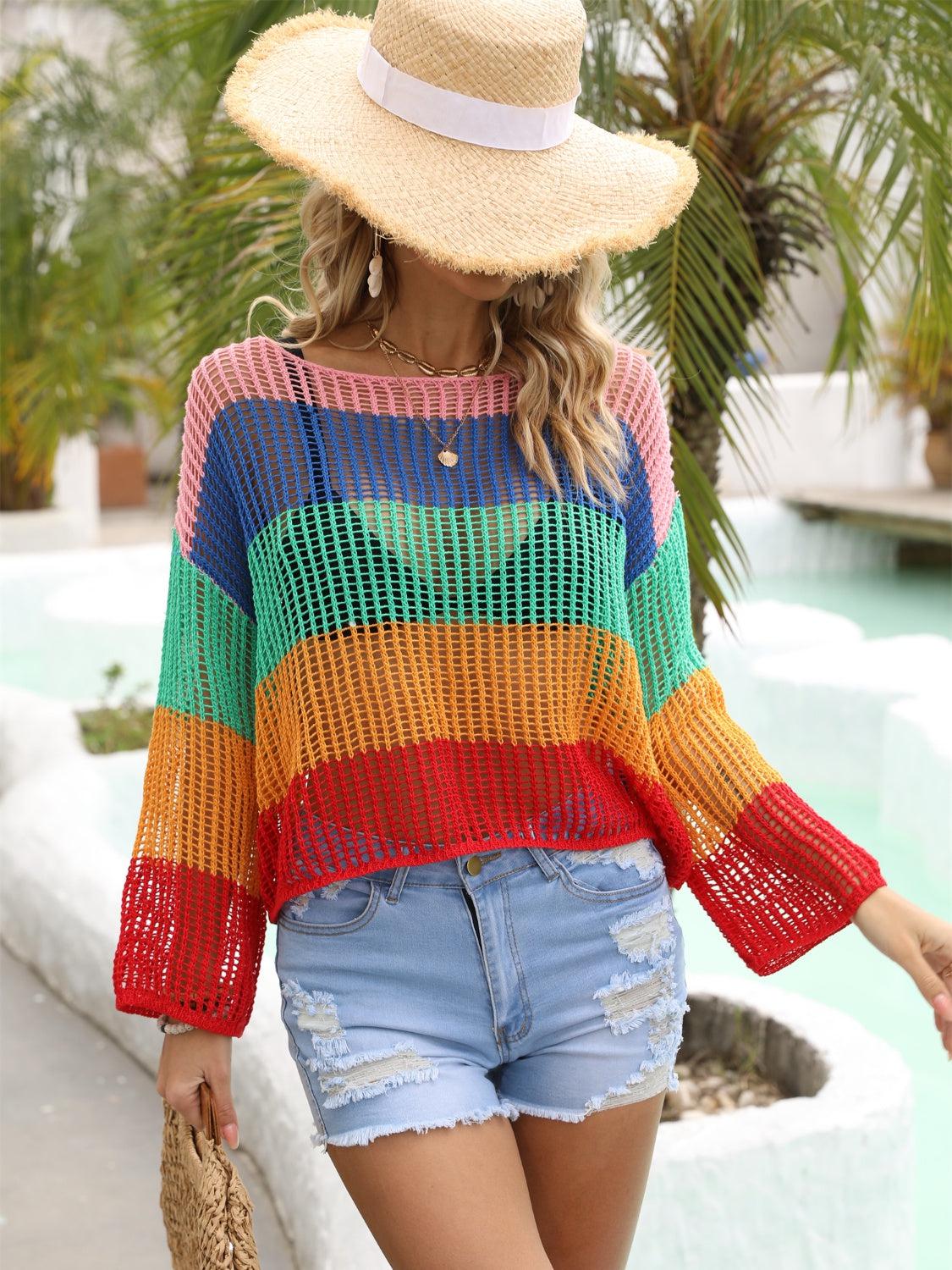 a woman wearing a colorful sweater and denim shorts