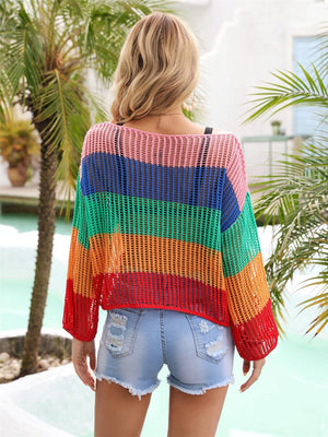 a woman wearing a multicolored sweater and denim shorts