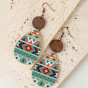 a pair of earrings with a wooden disc hanging from it