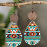 a pair of earrings hanging from a tree branch