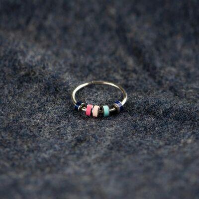 a gold ring with three different colored beads