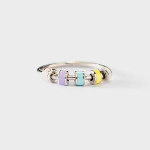 a silver ring with three different colored beads
