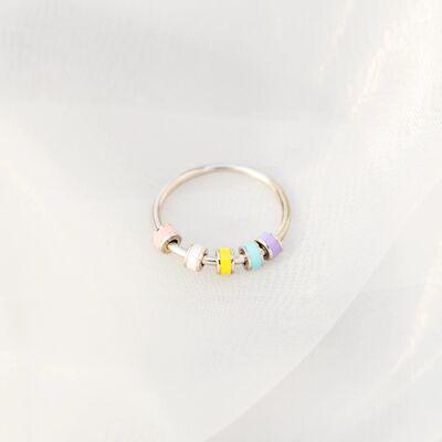 a silver ring with four different colored beads