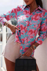 a woman in a pink and blue shirt holding a black purse