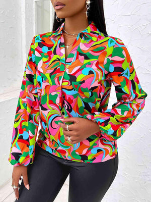 a woman wearing a colorful shirt and black pants