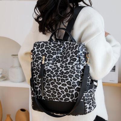 a woman carrying a black and white animal print bag