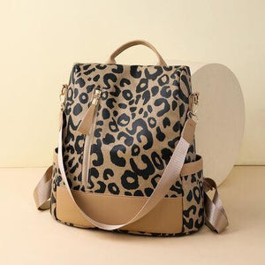 a leopard print bag with a tan strap