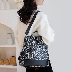 a woman holding a black and white animal print purse