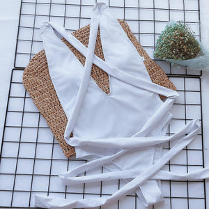 a white piece of clothing sitting on top of a tiled floor