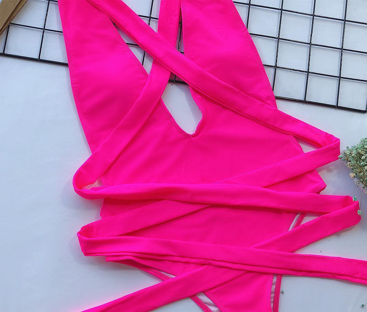 a woman's pink swimsuit laying on top of a keyboard