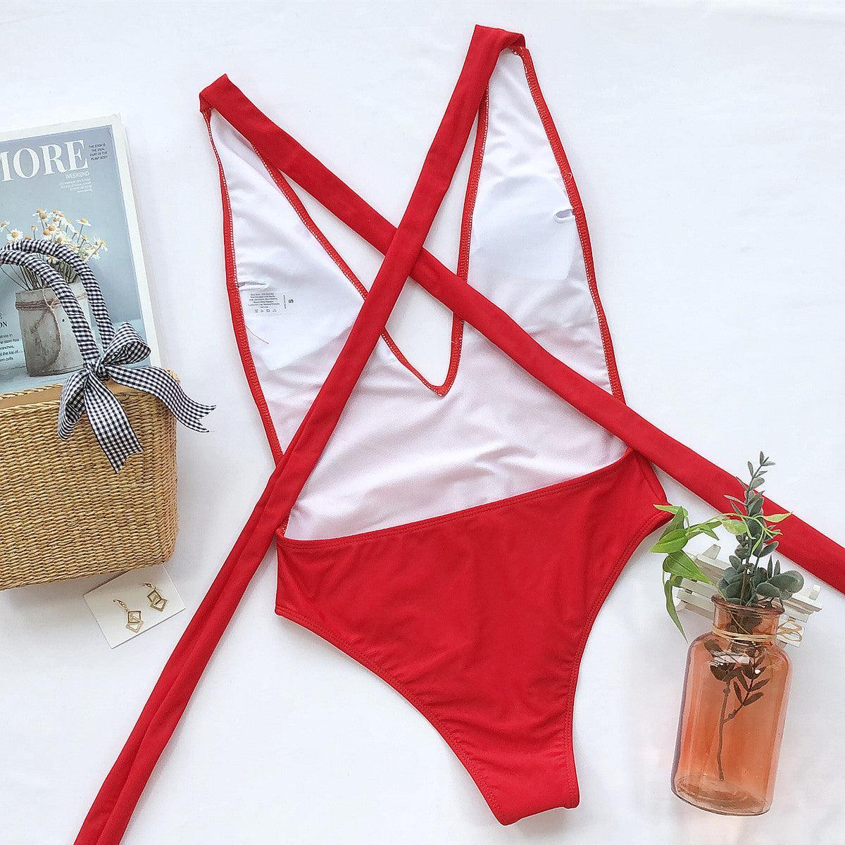 a red bikinisuit with a magazine and a vase of flowers